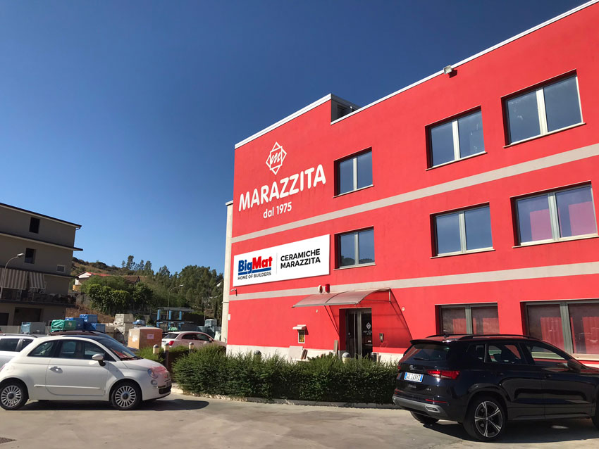 Facciata del punto vendita di BigMat Ceramiche Marazzita, con automezzi e materiali edili vari